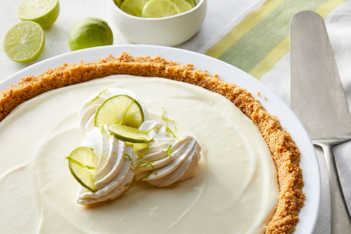 No Bake Key Lime Pie on a pie plate with some sliced lemons