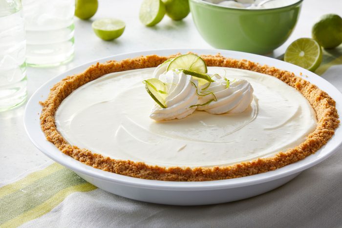 No Bake Key Lime Pie on a pie plate with some sliced lemons