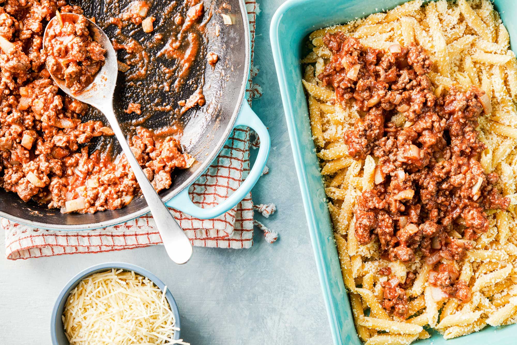 Adding cooked beef over pasta in a large skillet