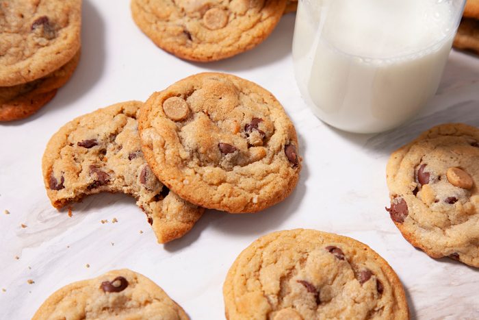 Peanut Butter Oatmeal Chip Cookies arranged on a white table with a glass of milk on side