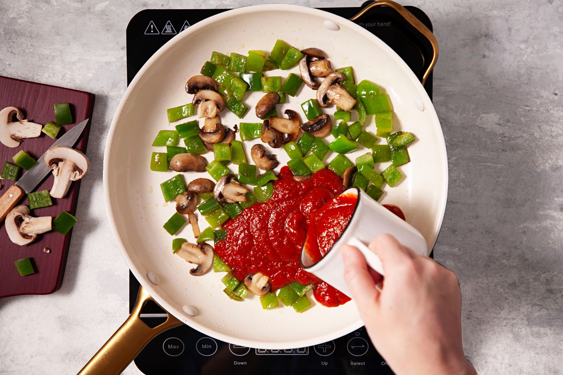 Adding sauce in vegetables being cooked in skillet