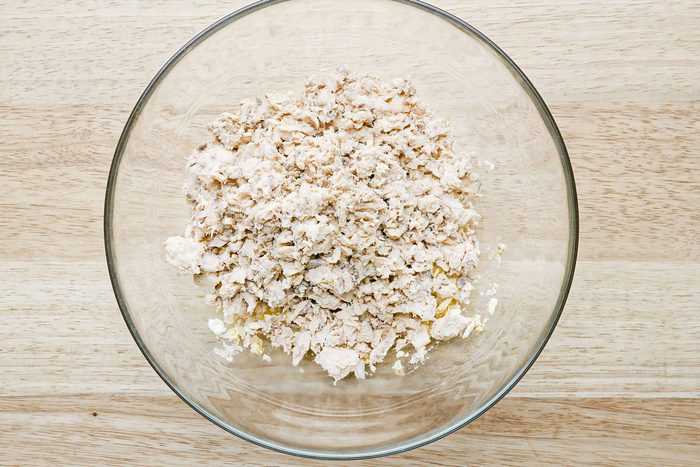 minced salmon in a glass bowl on a wooden surface