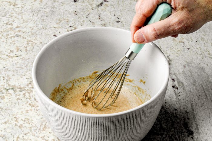 whisking sauce in bowl