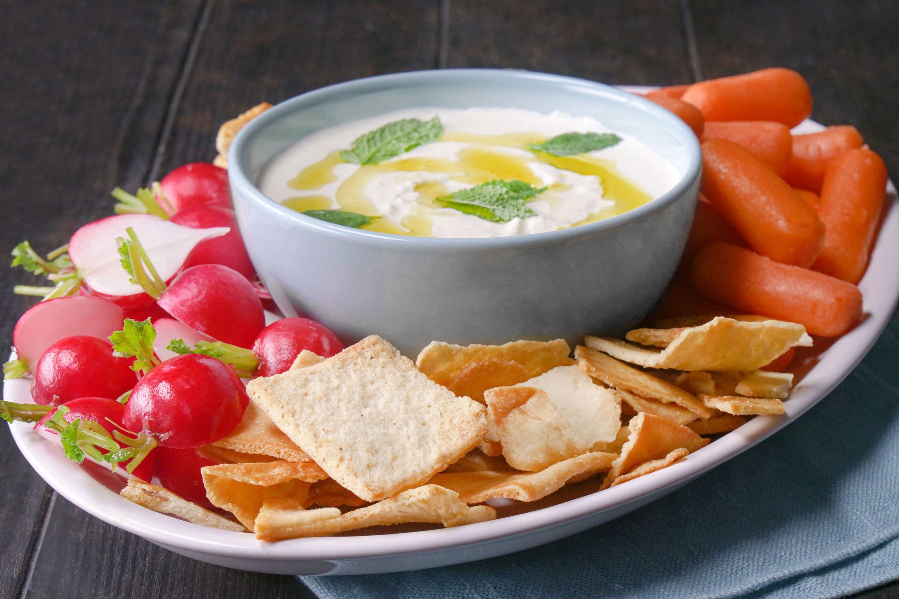 Whipped Feta Dip with other vegetables and snacks in a plate on a wooden table