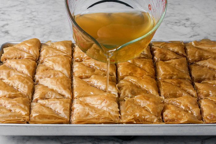 Pouring the syrup over Baklava