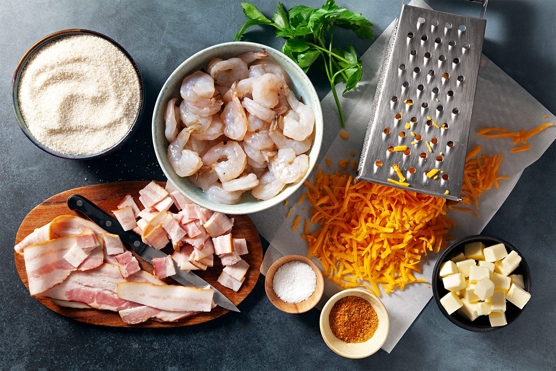 A table with ingredients of cheesy cajun shrimp and grits
