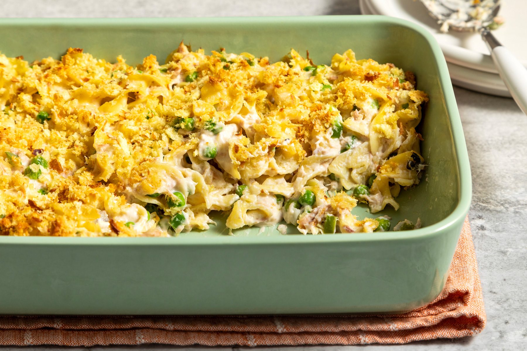 A green dish of creamy tuna noodle casserole