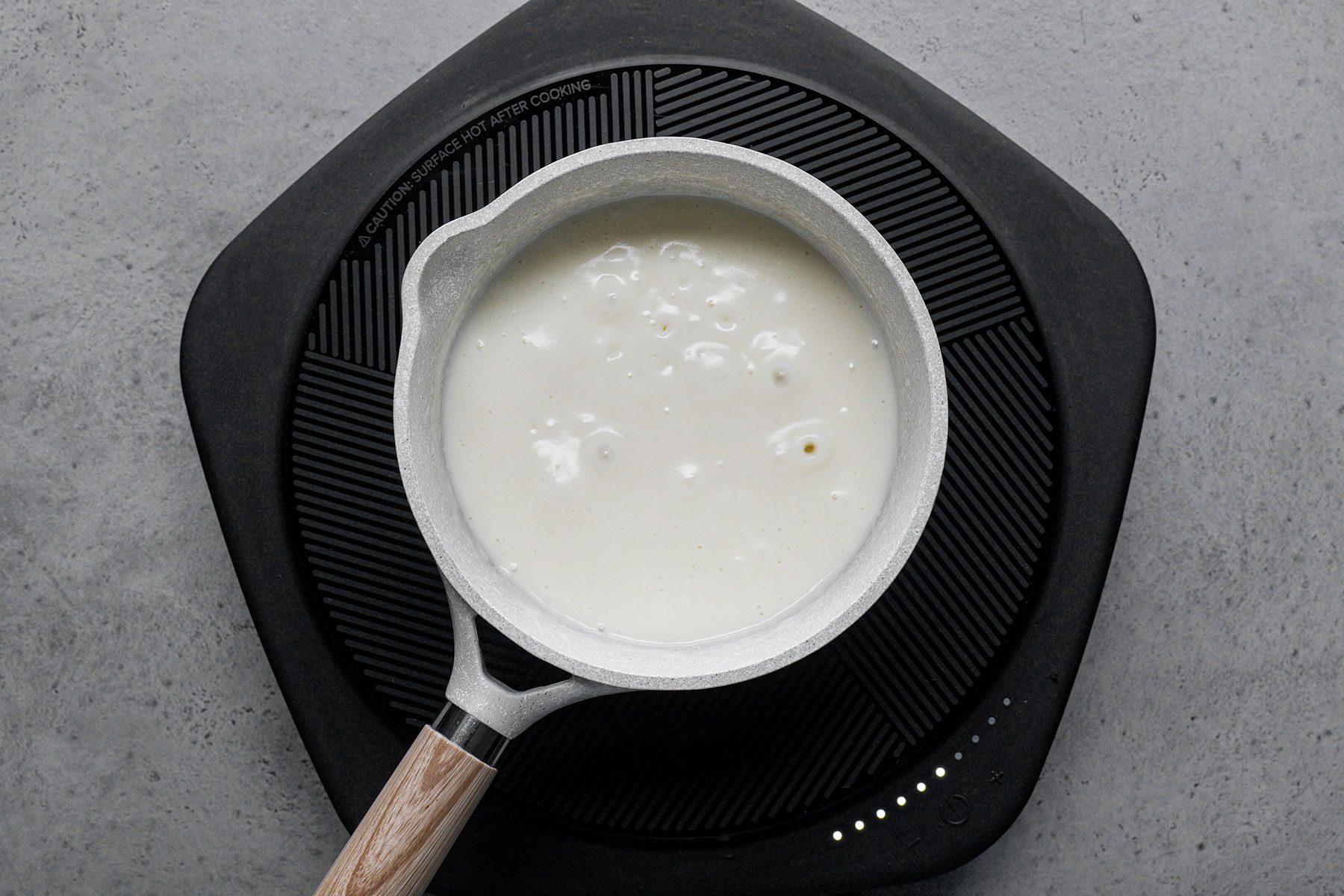 Flour mixing in melting butter in saucepan over heat