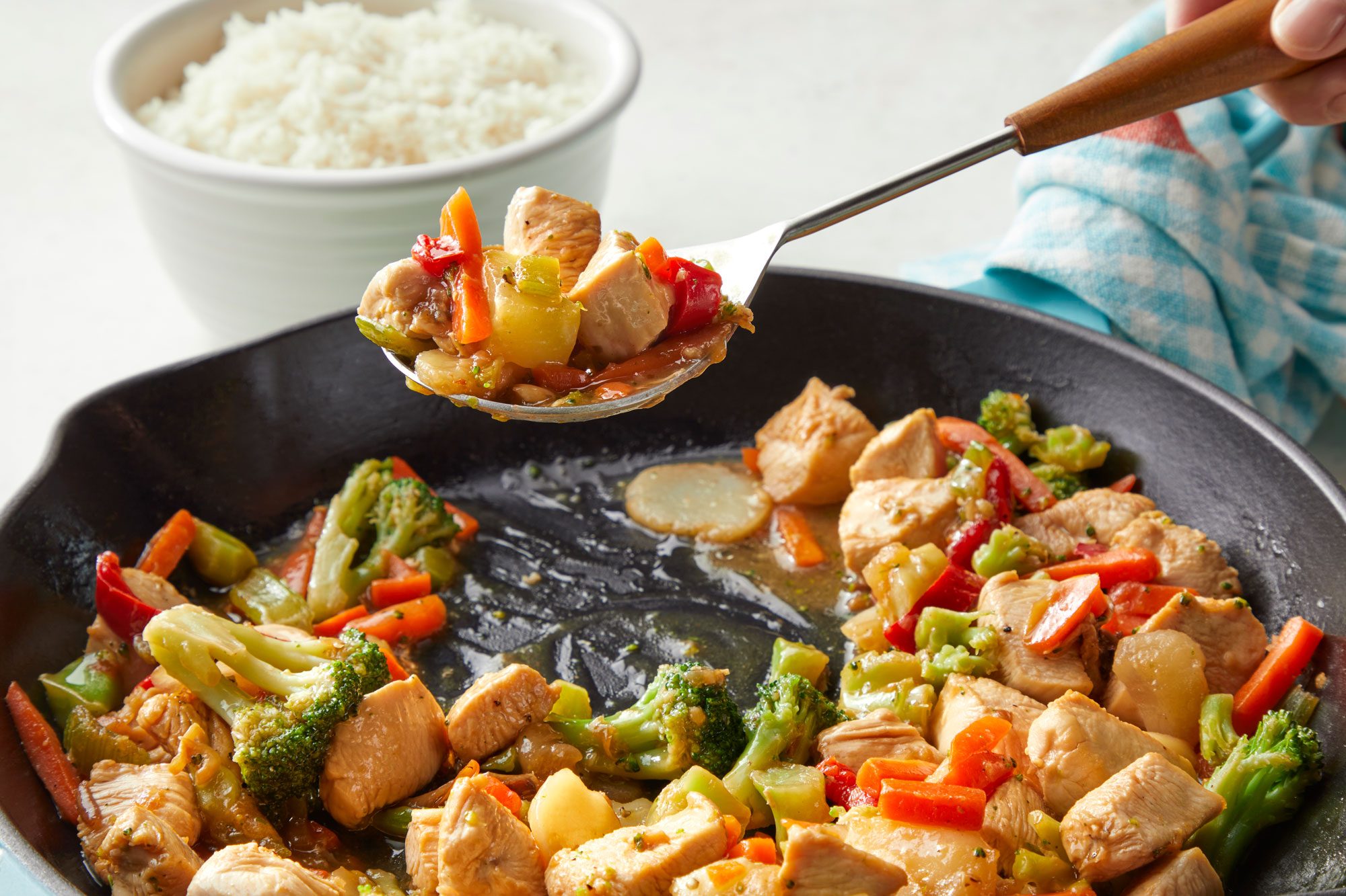 Honey Chicken Stir-Fry in a pan and a bowl of rice placed next to it.