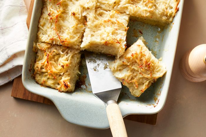 A tray of potato kugel with a spatula