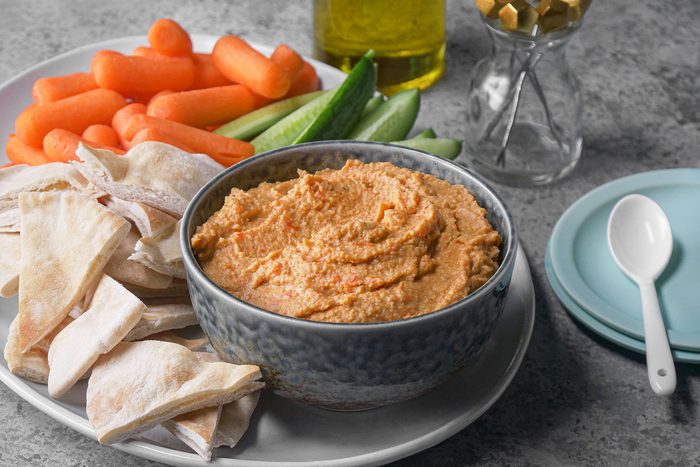 Humus served with pita bread, carrots, cucumbers and crackers