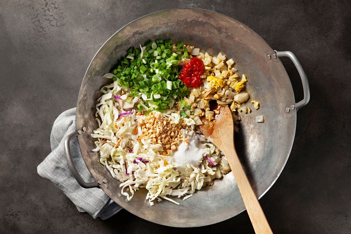 Add the coleslaw mix, green onions, vinegar, sugar, soy sauce, fish sauce, chilli garlic sauce and peanuts in large wok