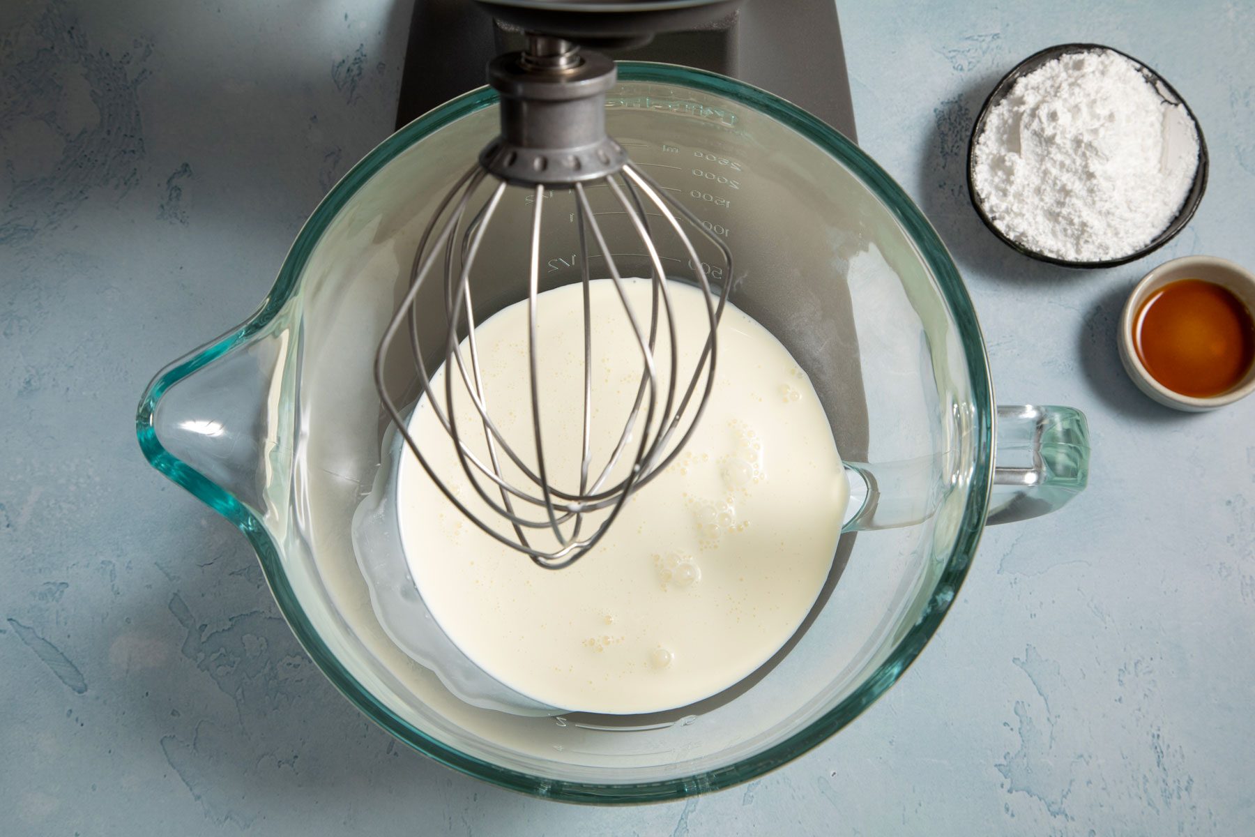 Whipping cream in in a big jar on a countertop