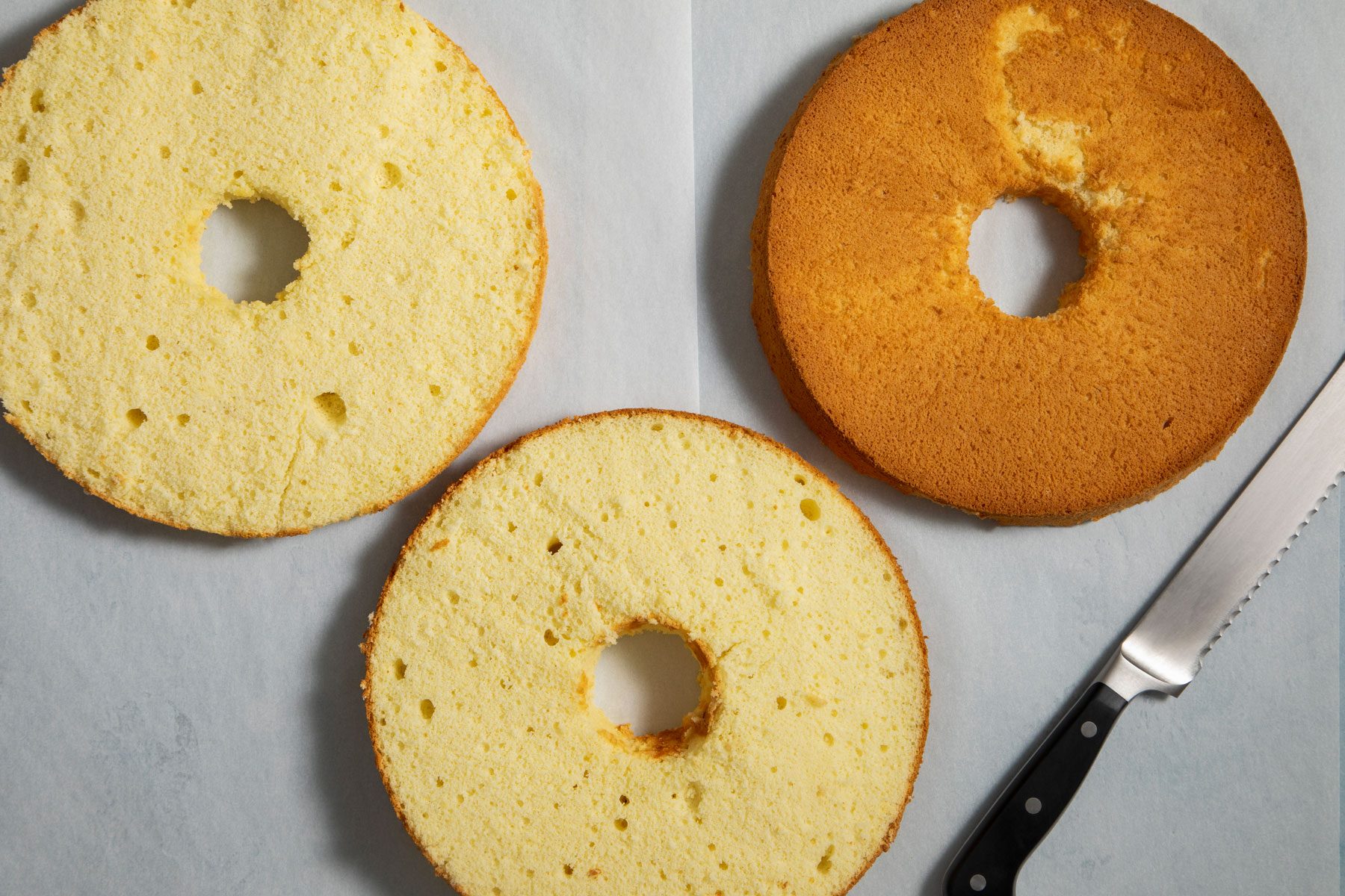 Layers of cake arranged on a countertop with a knife