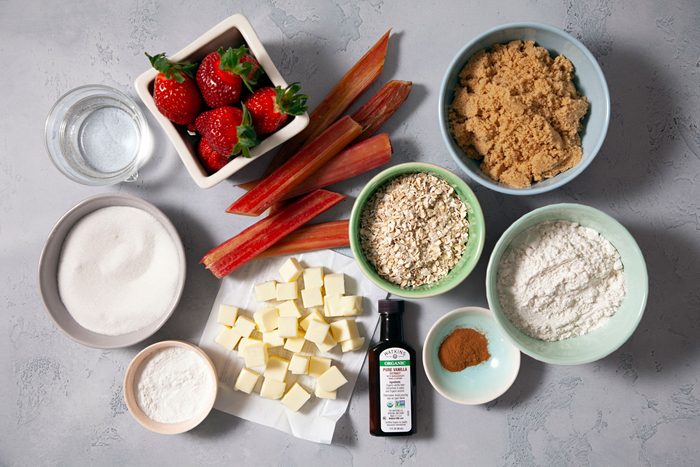 Flour oats butter strawberries arranged on a marble countertop