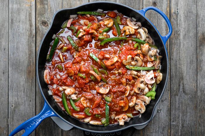 Making sauce in skillet with mushrooms, cashews and other ingredients