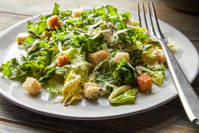 Kale Caesar Salad served on white plate with fork