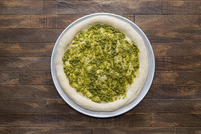 Pesto spread over the crust