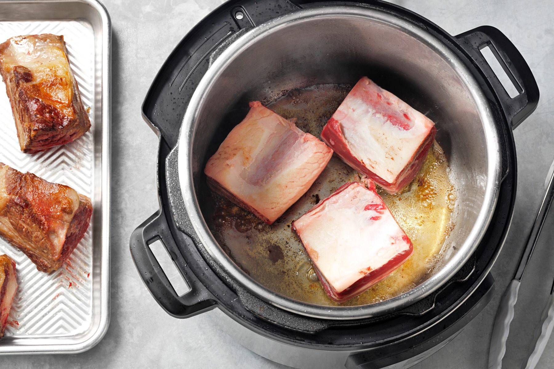 Beef ribs are being cooked in a pressure cooker