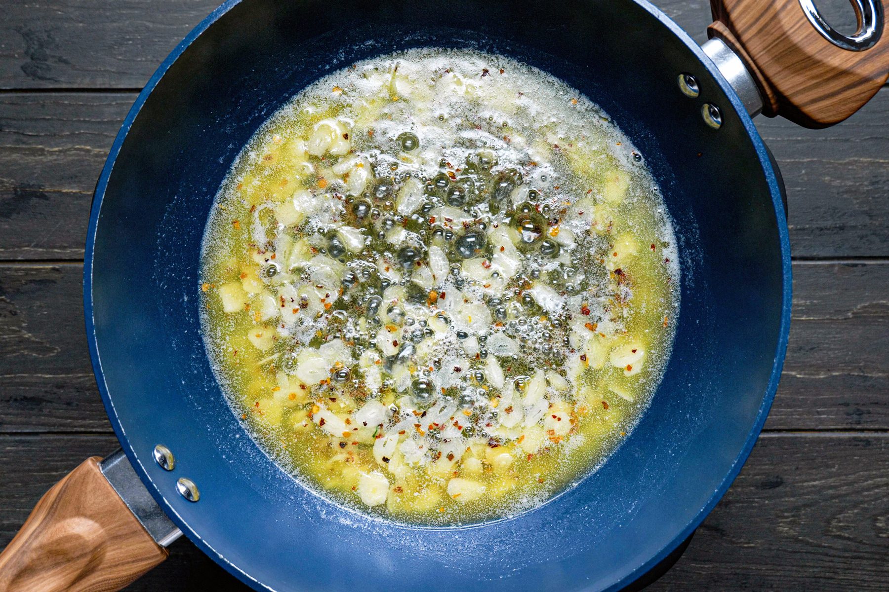 A blue pan with pasta in boiling salted water