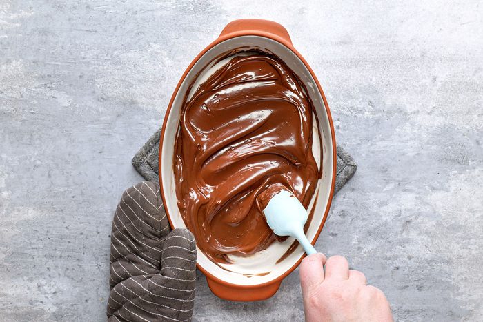 Stirring melted chocolate in baking dish
