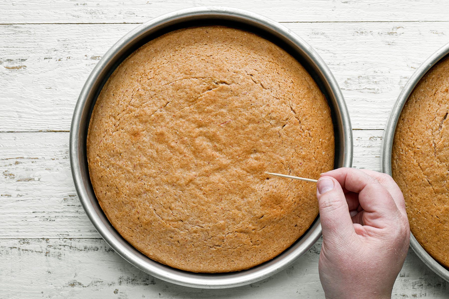 Checking the baked cake with inserting toothpick