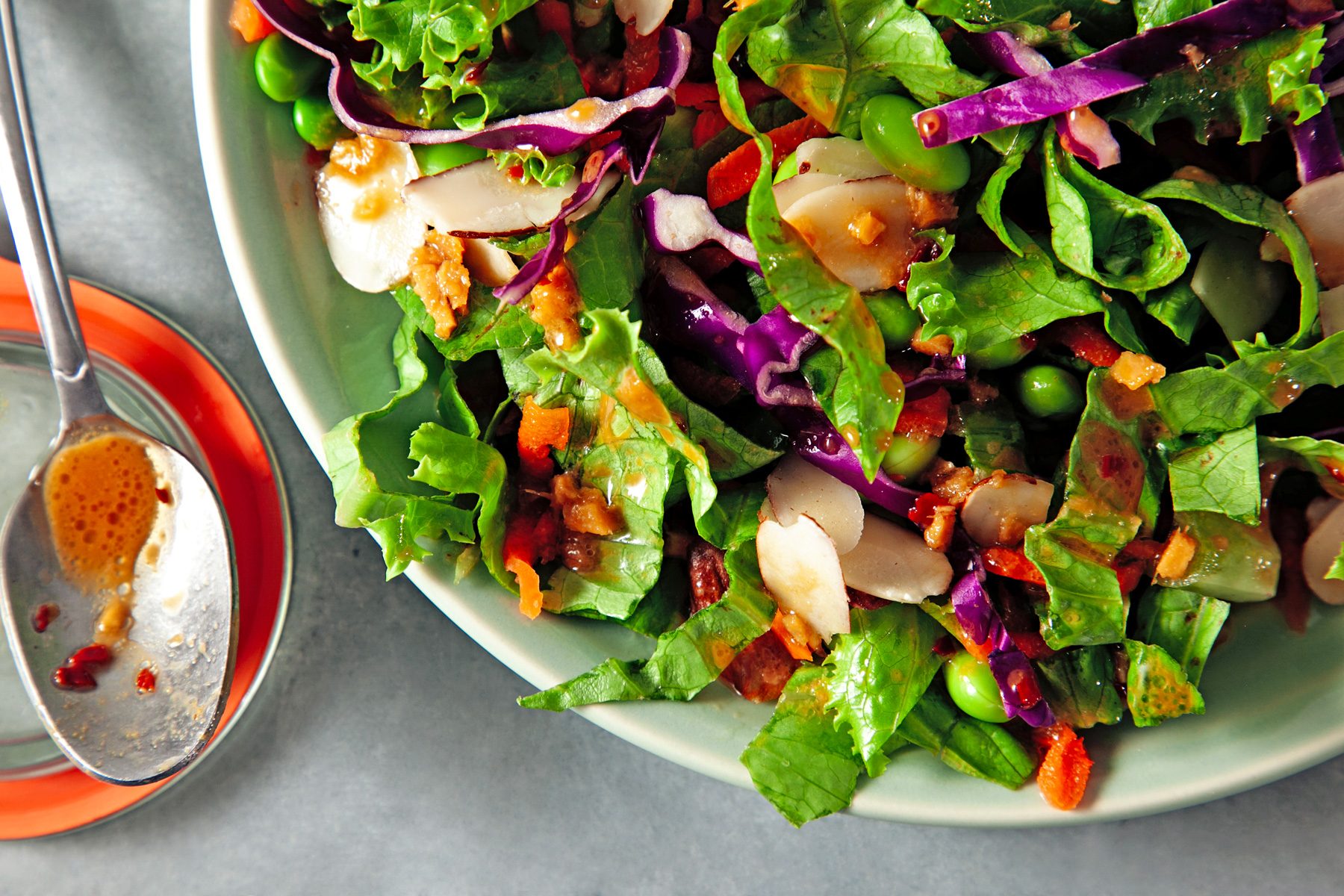 Fresh vegetable salad in a bowl, drizzled with Asian Salad Dressing