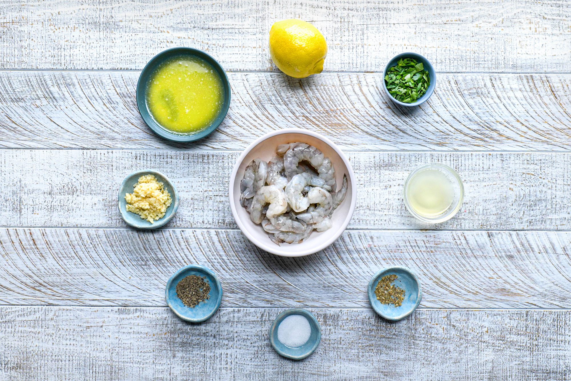 overhead shot; white wooden background; all ingredients for baked shrimps;