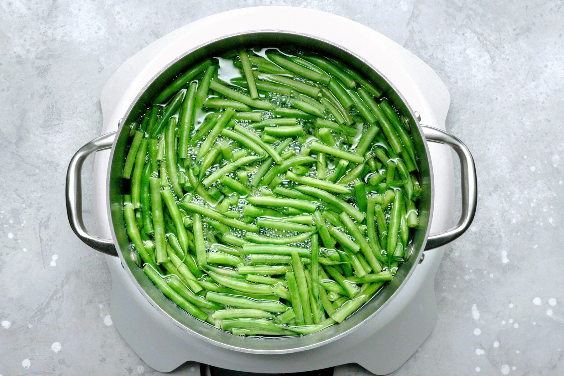 A pot of green beans simmering in boiling water