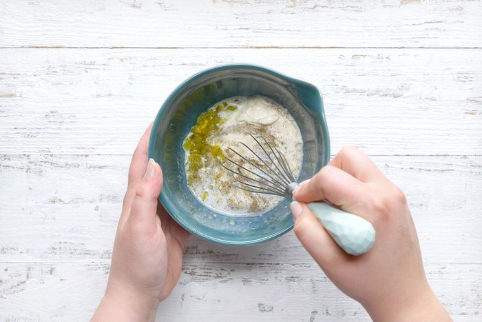 overhead shot of combine mayonnaise, milk, relish and pepper in a small bowl