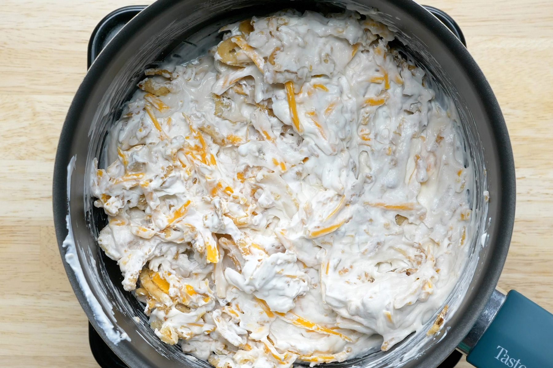 Cream of mushroom soup mixed with cheese and other ingredients in a saucepan