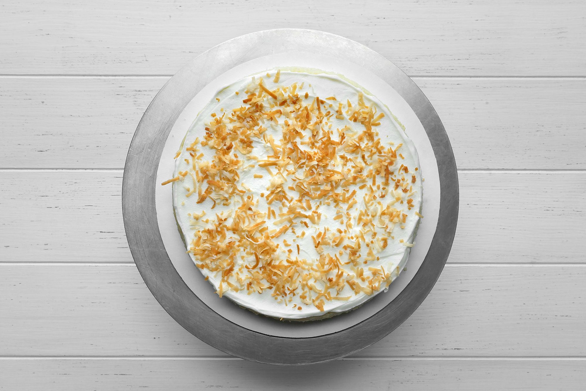 Overhead shot of sprinkled with 1/3 cup cocount over top; white wooden background;