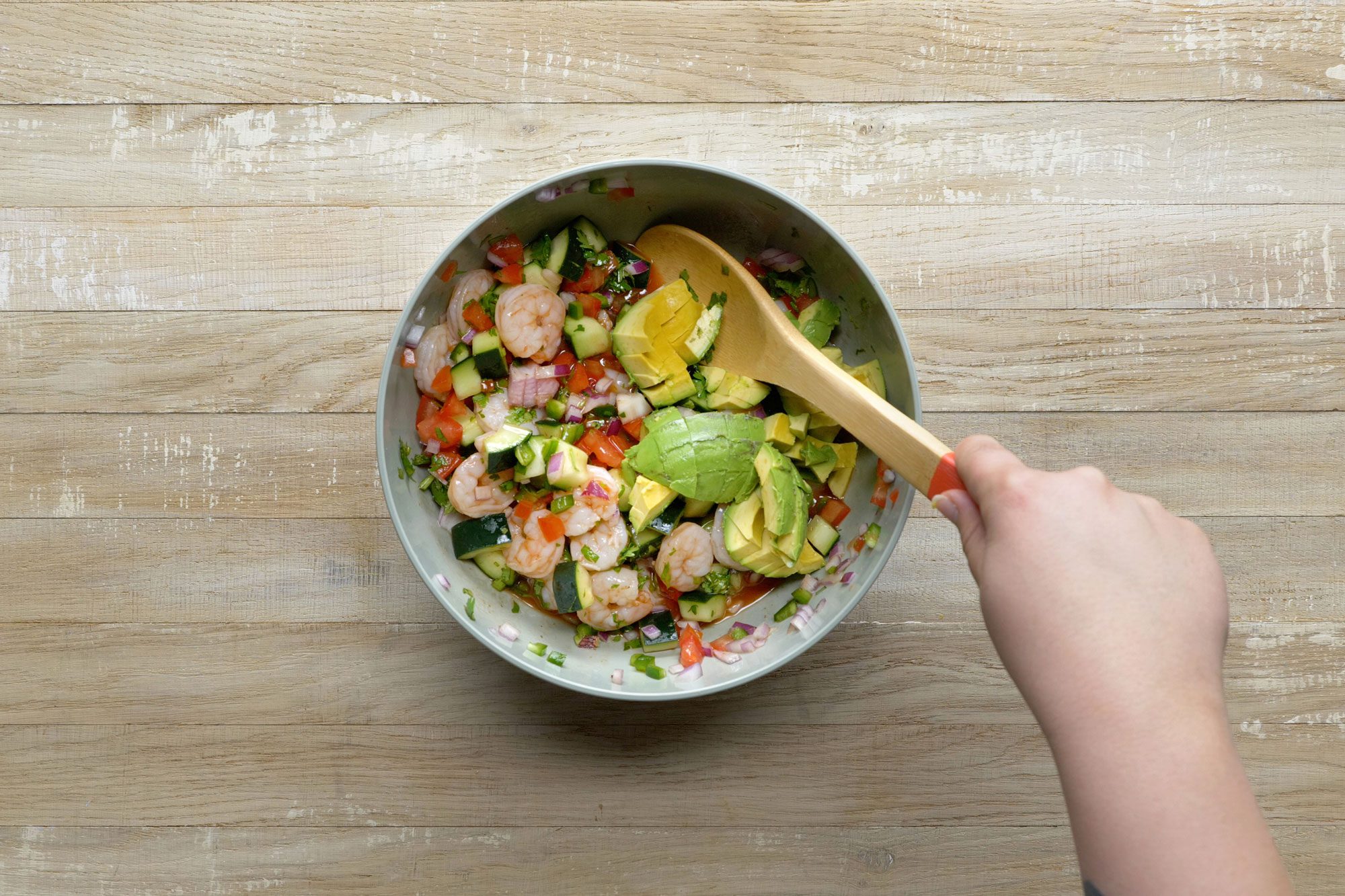 Pour the sauce over the shrimp mixture and stir to coat and gently fold the avocado