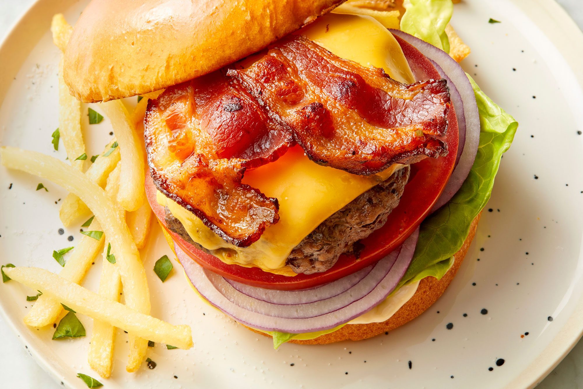 Close view shot of Easy Oven-Baked Burger; served on plate with fries; marble background;