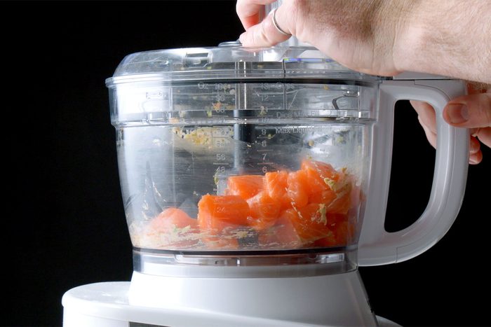 Close shot of place remaining salmon in food processor; pulse until coarsely chopped and add to puree;