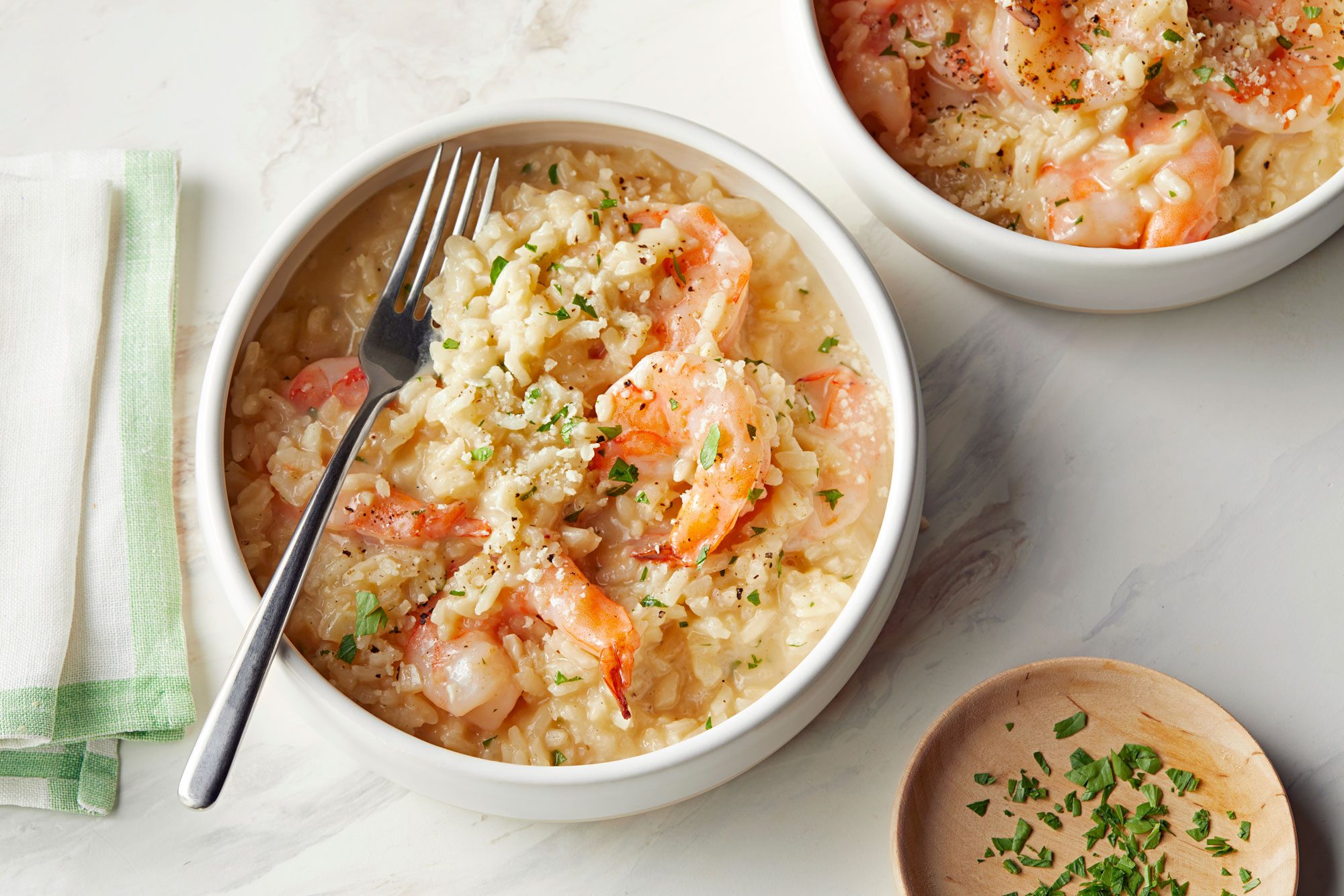 Shrimp Risotto served in a white bowl on marble surface