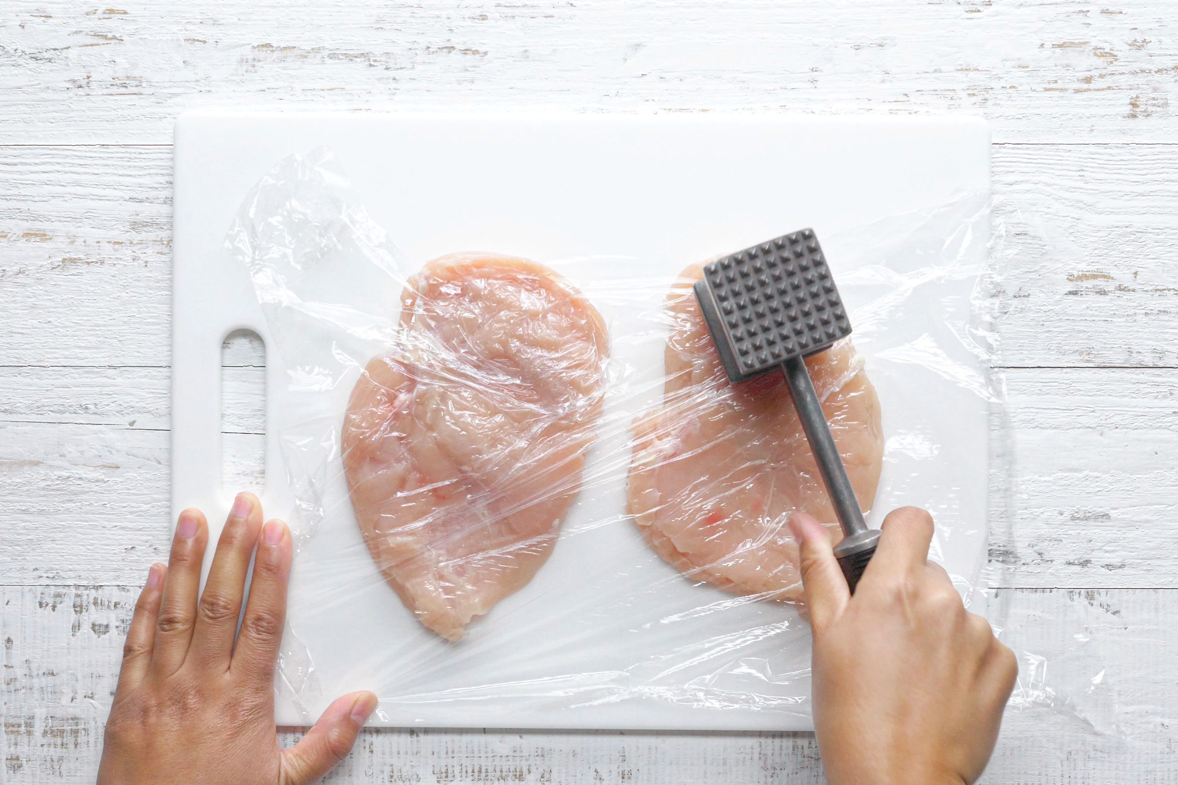 flattening chicken with a meat mallet