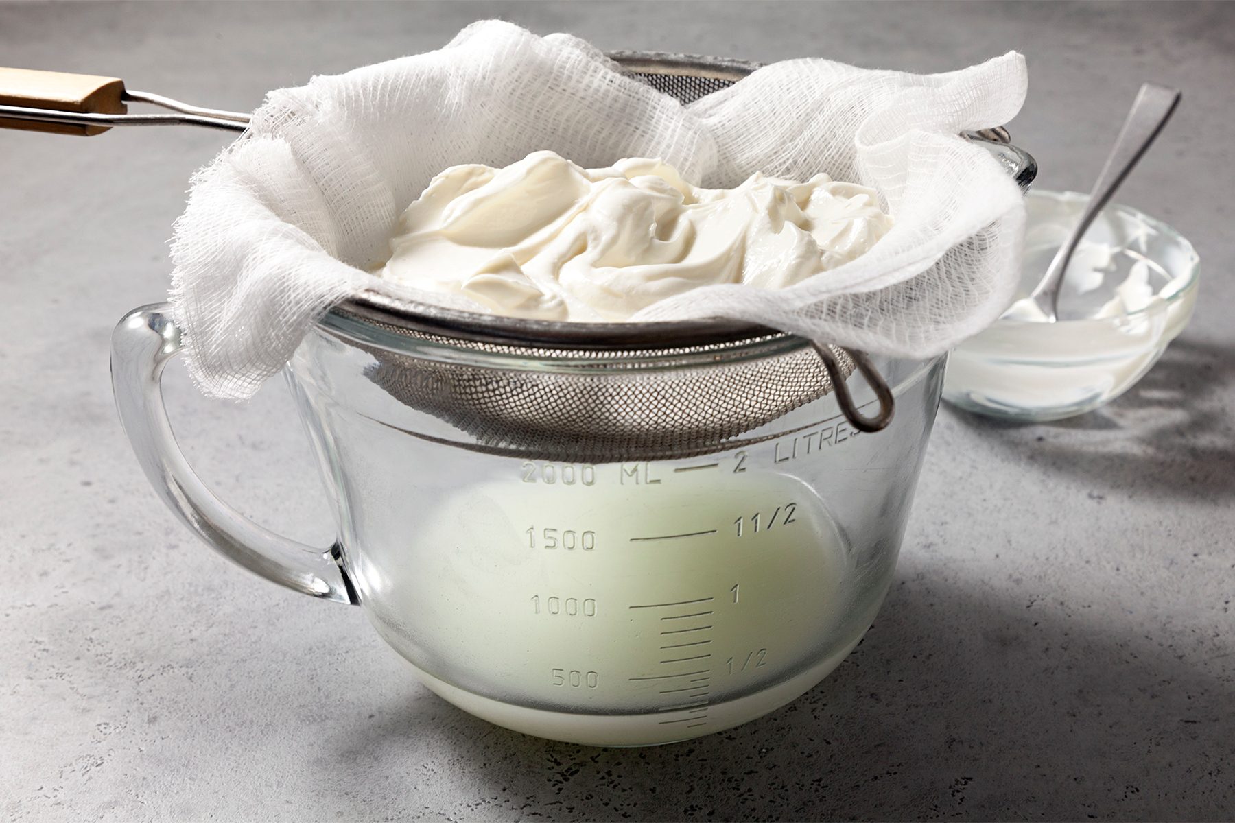 line a fine mesh strainer with two layers of cheesecloth; Place yogurt in strainer over a bowl