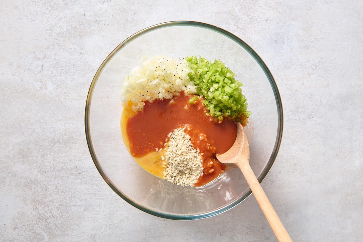 Combining bread crumbs, celery, onion, eggs, Buffalo sauce, garlic and pepper in a bowl