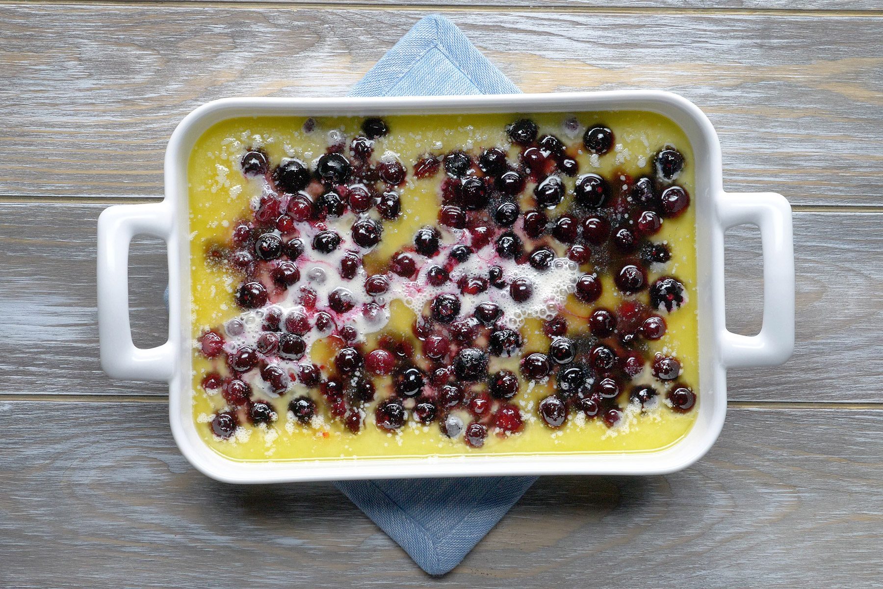 overhead shot; wooden background; Added berry mixture over batter;