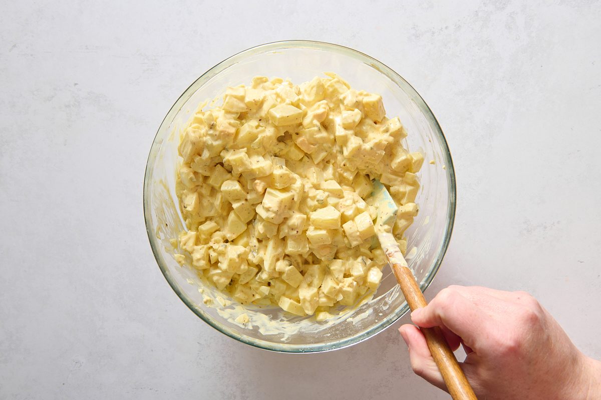 Combining the potatoes with the egg salad mixture