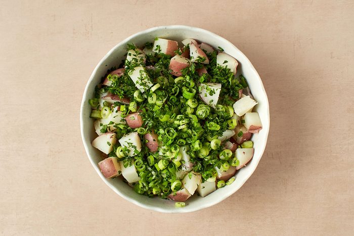 Add scallions and parsley to potatoes.