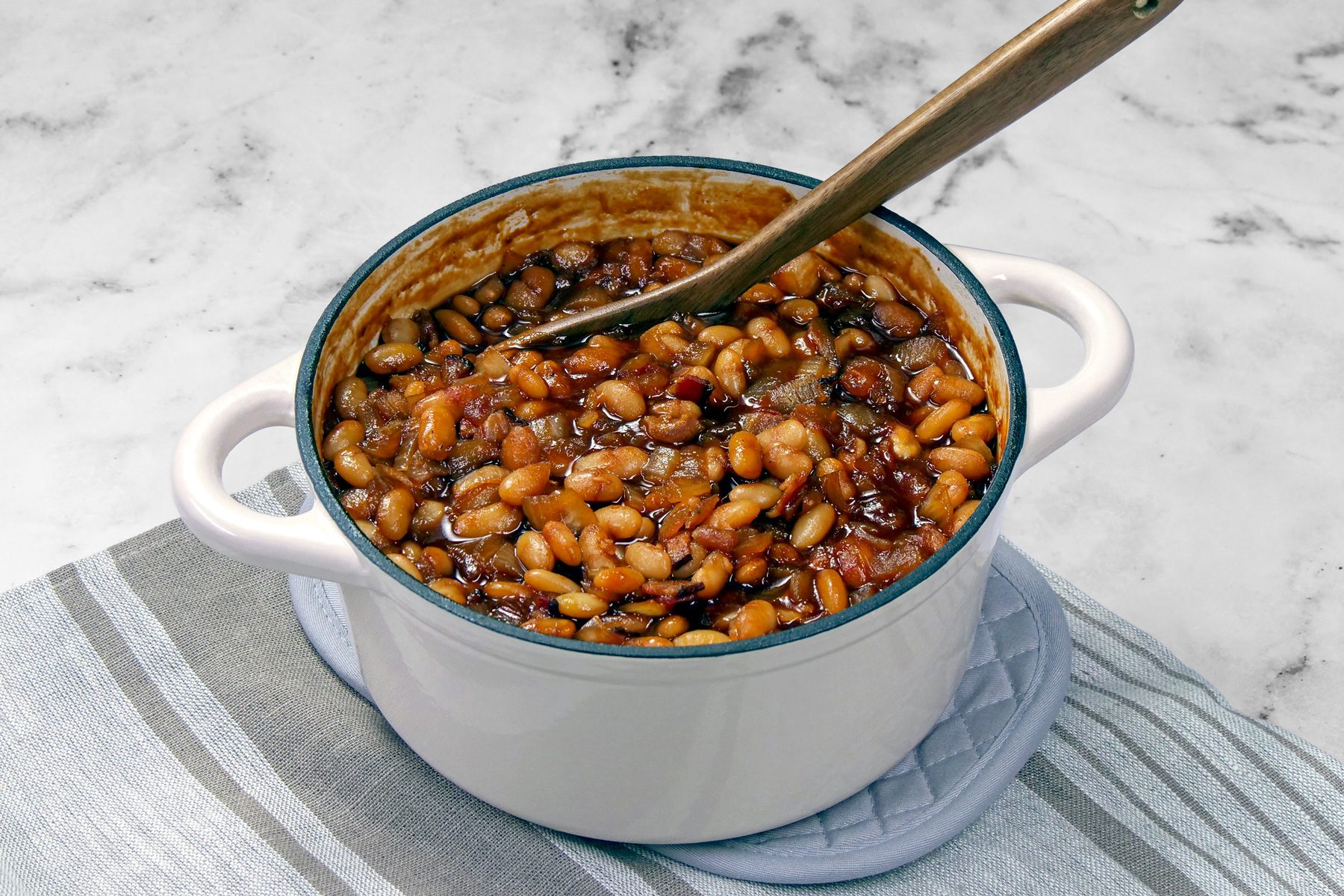 Baked Boston beans in a pot with wooden ladle