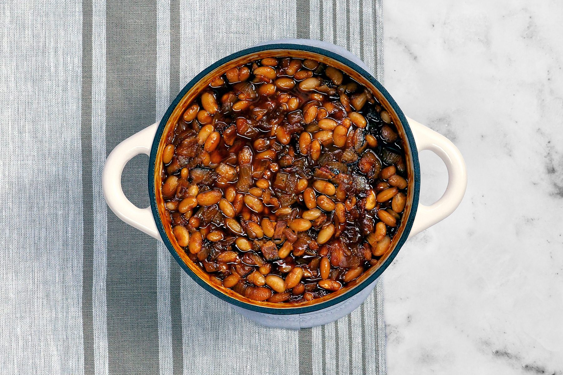 Top shot of Boston Baked Beans in a dish on a grey table cloth