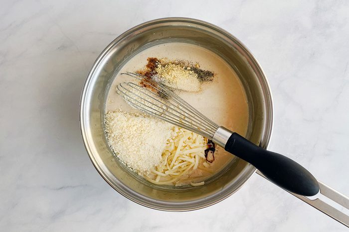 How to make Taste of Home's Cauliflower Gratin, step 2: adding cheese and milk to roux to make a thick sauce