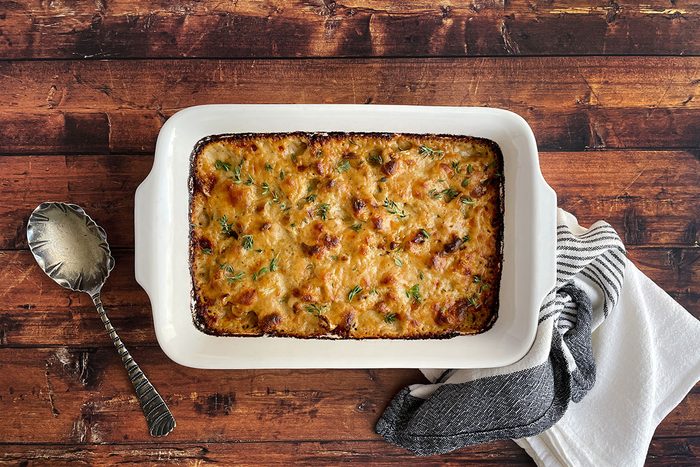 Overhead shot of Taste of Home's Cauliflower Gratin in a baking dish on a dark wood background
