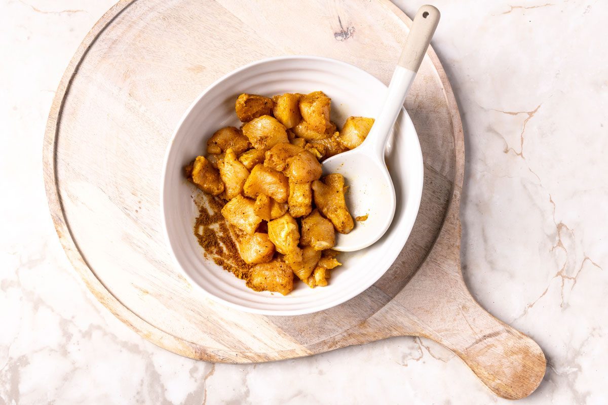 Marinating chicken in a seasoning blend for Chicken Curry Soup