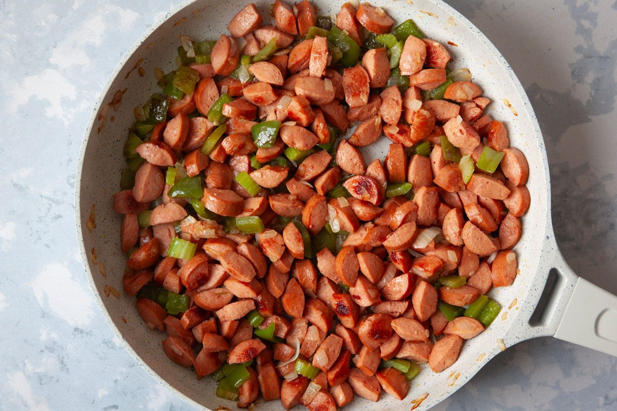 Step 3 of Taste of Home Chili Cheese Dog Casserole is adding in the hot dogs to brown