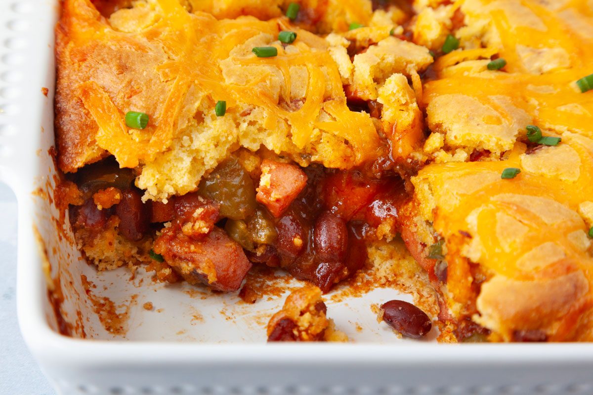 close up of Chili Cheese Dog Casserole in an white 8-inch baking dish