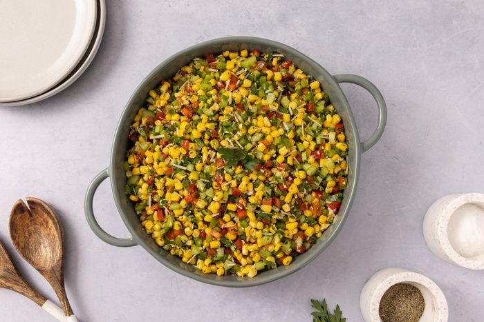 Corn salad ready served in round ceramic dish.